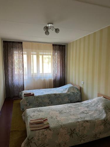 a hotel room with three beds and a window at Apartment on Karja in Narva-Jõesuu