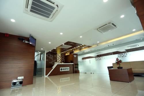 a lobby of a building with a air conditioner on the ceiling at Hotel Avista in Vadodara