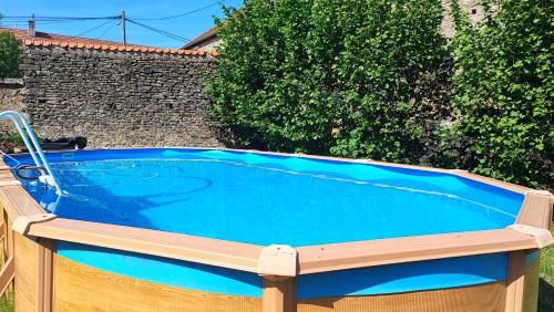 - une grande piscine dans une cour avec une terrasse en bois dans l'établissement Calme et confort à la campagne en Bourgogne vinicole,, à Aubigny-la-Ronce
