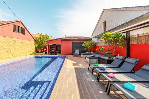 an outdoor swimming pool with chaise lounge chairs next to a house at Aroeira Pool House by Lisbon-Coast vacation in Charneca