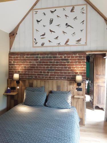 - une chambre avec un mur en briques et un lit dans l'établissement Les Charmilles de Valencendre, à La Calotterie