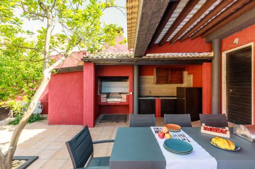 a patio with a table and chairs and a kitchen at Aroeira Pool House by Lisbon-Coast vacation in Charneca