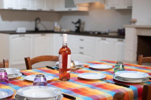 a bottle of wine sitting on a table with plates at La Tavernetta di Elisa in Calimera