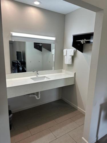 ein Bad mit einem Waschbecken und einem Spiegel in der Unterkunft Oakwood Inn in Oakdale