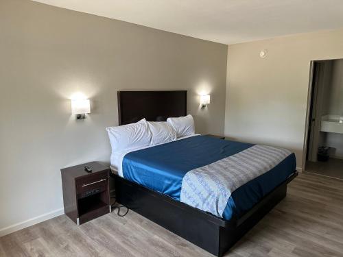 ein Hotelzimmer mit einem Bett und einem Nachttisch in der Unterkunft Oakwood Inn in Oakdale