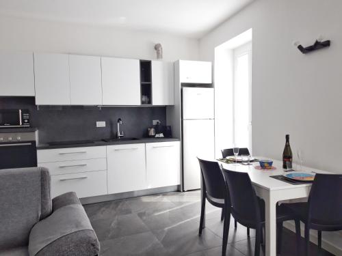 阿爾傑尼奧的住宿－Al Pontile - by My Home In Como，厨房配有白色橱柜和桌椅