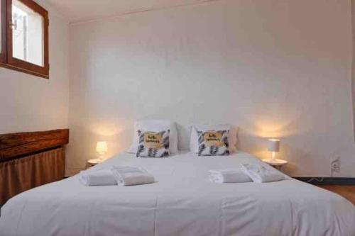 a bedroom with a large white bed with two lamps at La Ciotat : Marius Appartement en duplex très cosy in La Ciotat