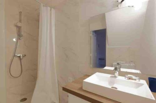a bathroom with a sink and a shower with a mirror at La Ciotat : Marius Appartement en duplex très cosy in La Ciotat