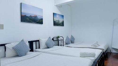 quatro camas num quarto com paredes brancas em 24 Poshtel Chiangmai em Chiang Mai