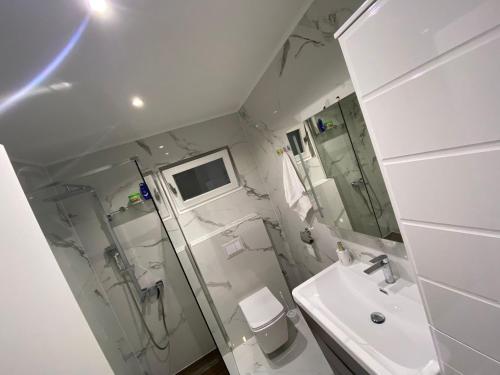 a bathroom with a shower toilet and a sink at Villa Vukas in Mostar