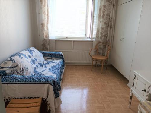 Zimmer mit einem Sofa, einem Stuhl und einem Fenster in der Unterkunft Cozy Nest, apartement in the center of Rovaniemi in Rovaniemi