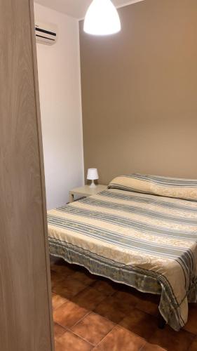 a bedroom with two beds and a light on the wall at Home Plutone in Giardini Naxos