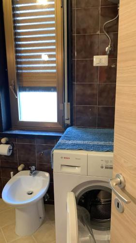 a bathroom with a washing machine and a sink at Home Plutone in Giardini Naxos