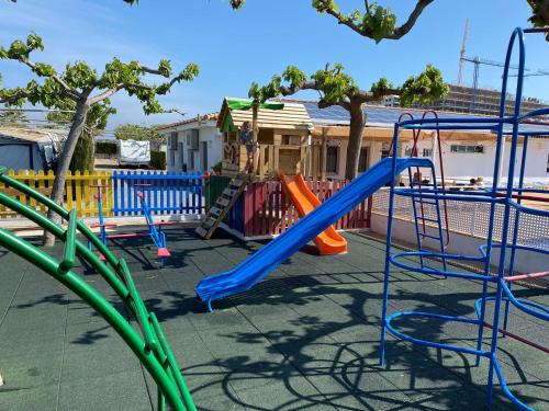 a playground with a slide and swings at Camping Riberamar in Oropesa del Mar