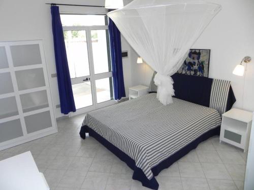 a bedroom with a bed with a canopy and a window at villa Annarè in Torre dell'Orso