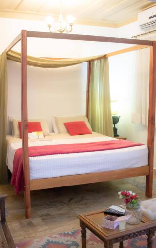 a canopy bed in a room with a table at Casa Perpetua Hotel D Charm in Manaus