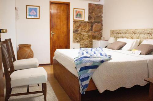 a bedroom with a large bed and a chair at Casa Perpetua Hotel D Charm in Manaus
