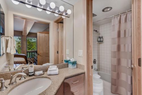 a bathroom with a sink and a toilet and a mirror at Interlude Condominiums 2-Bedroom Unit 202 in Snowmass Village