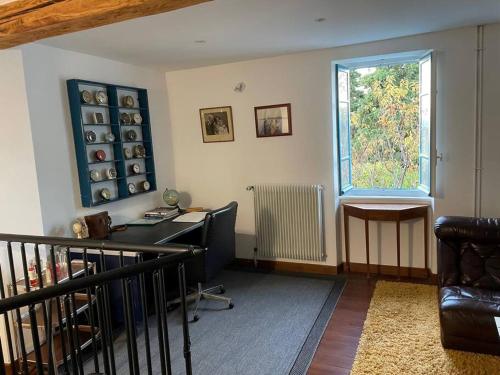 uma sala de estar com uma secretária e uma janela em Rue Basse - village house overlooking the Pyrenees em Montréal