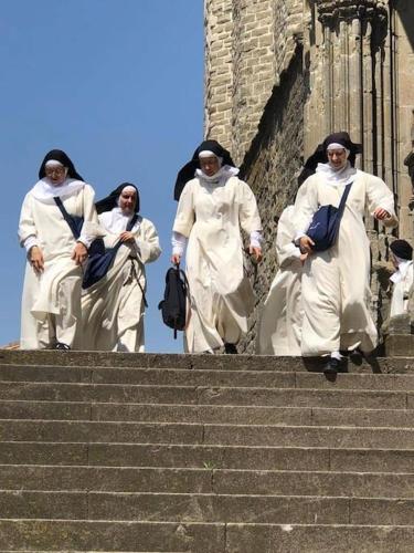 a group of nuns walking up some stairs at Rue Basse - village house overlooking the Pyrenees in Montréal