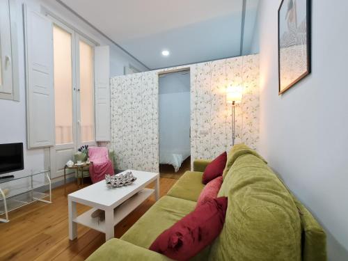 マドリードにあるAsAtHome Arenal Apartmentのリビングルーム(緑のソファ、テーブル付)