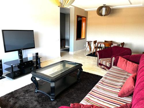 a living room with a couch and a tv at Short Stay Apartment aéroport casablanca in Nouaseur