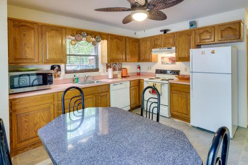 a kitchen with a table and a white refrigerator at Fire Pit, Kayak and Gas Grill Pocono Lake Home! in Pocono Lake