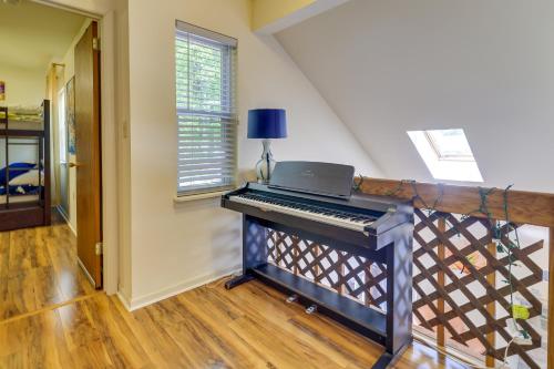 a piano in a living room with a staircase at Fire Pit, Kayak and Gas Grill Pocono Lake Home! in Pocono Lake