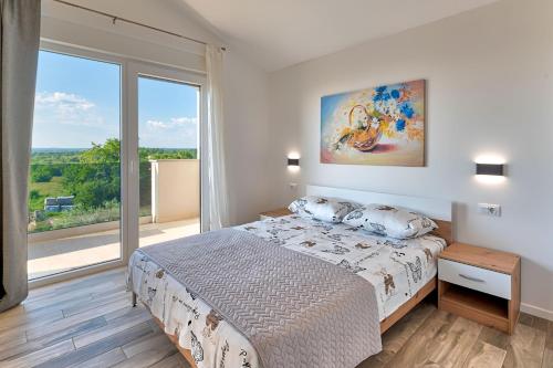 ein Schlafzimmer mit einem Bett und einem großen Fenster in der Unterkunft Villa Tami in Hreljići