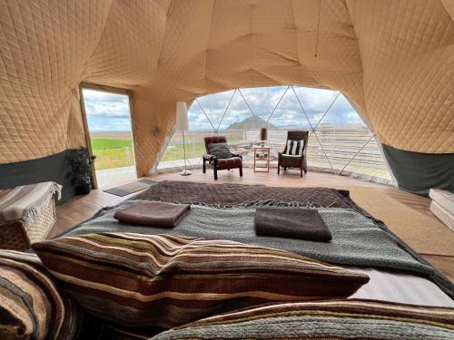 um quarto com uma cama grande numa tenda em Aurora Dome on the South Coast em Hvolsvöllur