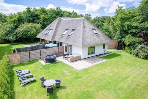 an aerial view of a small white cottage with a yard at The island life texel met jacuzzi in De Koog