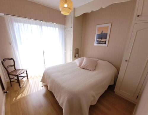 ein Schlafzimmer mit einem weißen Bett und einem Fenster in der Unterkunft Bien-être & Panorama - Les Gîtes de la Côte d'Amour in Le Croisic