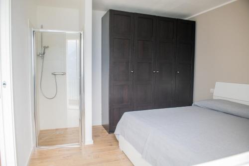 a bedroom with a bed and a glass shower at Residence Il Poggio in Dorio