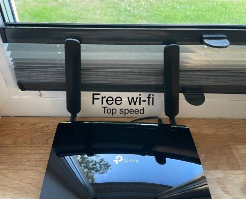 een venster met een bord dat zegt gratis wifi topsnelheid bij Centre Premium in Pärnu
