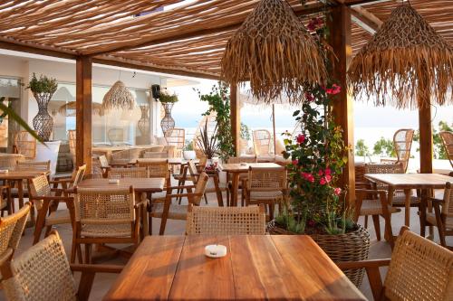 un ristorante con tavoli e sedie in legno e fiori di Regina Blu a Vlorë