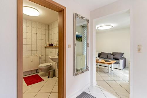 a bathroom with a toilet and a living room with a couch at Ribeiro Tesouro in Friesenheim