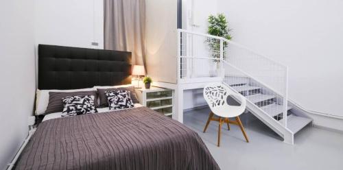 a bedroom with a bed and a white staircase at My City Home - Acogedor estudio en Ciudad Lineal in Madrid