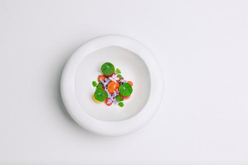 a plate of food with vegetables on a white background at Bela Vista Hotel & Spa - Relais & Chateaux in Portimão