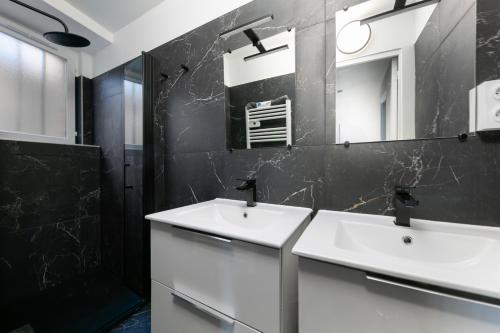 une salle de bain avec deux lavabos et un miroir dans l'établissement Maison entière Dinan centre - 5 chambres, à Dinan