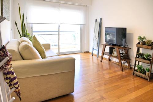 sala de estar con sofá y TV en Garage incluido! Buenos Aires - Villa Urquiza en Buenos Aires
