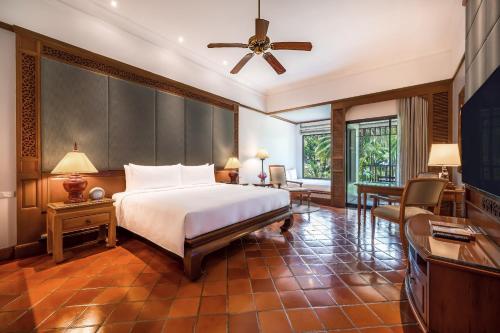 a bedroom with a bed and a desk and a television at JW Marriott Phuket Resort and Spa in Mai Khao Beach