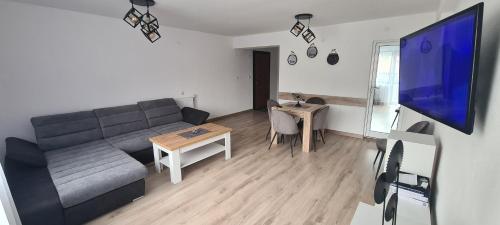- un salon avec un canapé et une table dans l'établissement къща за гости Сънрайс Чепеларе, à Chepelare