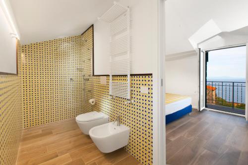 uma casa de banho com um WC, uma cama e uma janela em YourHome - Relais Loggia Li Galli em Massa Lubrense
