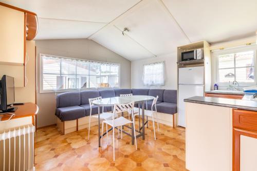 Il comprend une cuisine et un salon avec une table et un canapé. dans l'établissement Mobil Home Le Tokyo, à Noyelles-sur-Mer