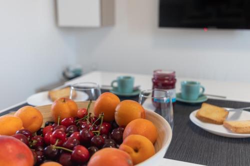 a bowl of fruit on a table with plates of food at Suite N12 - Luxury Apartment in Bari
