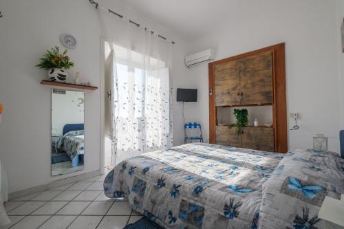 Schlafzimmer mit einem Bett mit blauer Decke in der Unterkunft Angela Appartament in Lipari