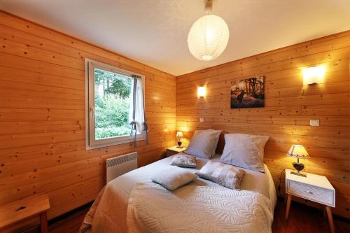 une chambre avec un lit avec des murs en bois et une fenêtre dans l'établissement Chalet Superbe Vue Sur Le Lac, à Gérardmer
