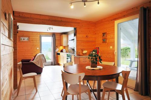 une cuisine et une salle à manger avec une table et des chaises dans l'établissement Chalet Superbe Vue Sur Le Lac, à Gérardmer