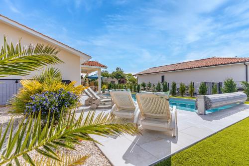 une cour avec des chaises et une piscine dans l'établissement Villa du Lac, à Gastes