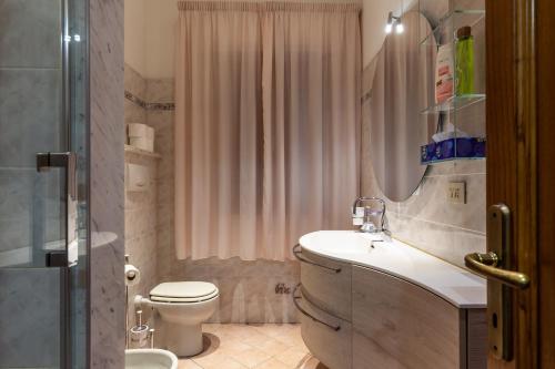 Un baño con lavabo, inodoro y ducha. en Casa Umbé, en Pietrasanta